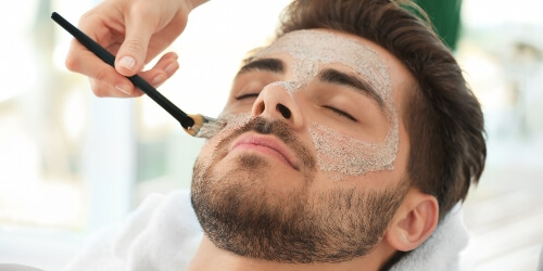 esthetician giving a client a facial mask