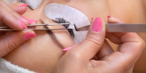 esthetician applying eyelash extensions