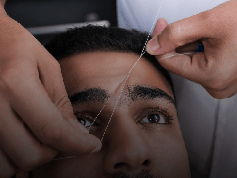 client getting their eyebrows threaded