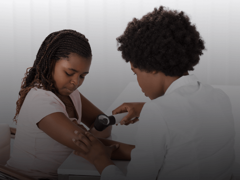 dermatologist looking at a patient's skin