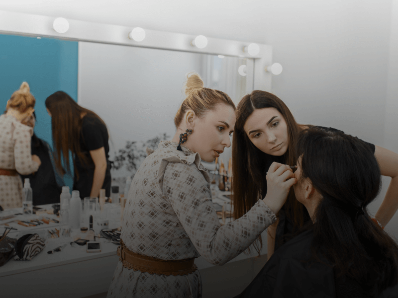 teacher showing students how to apply makeup